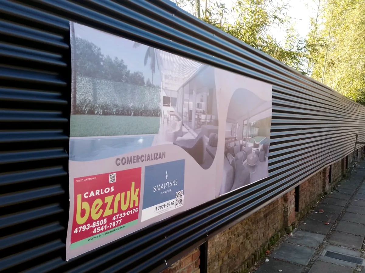Cartel instalado sobre un cerco negro